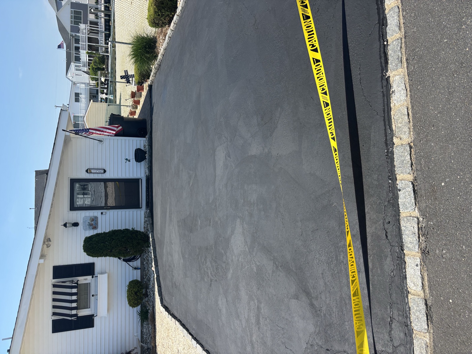 Freshly sealed driveway with caution tape — Monmouth County NJ